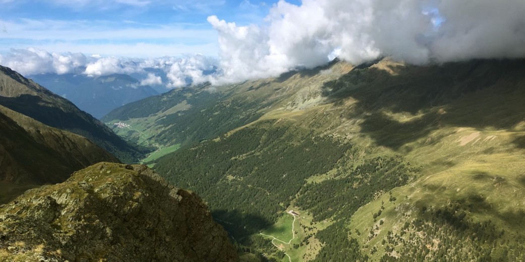 Weiter Blick vom Bergkamm in das tief eingeschnittene Matschertal mit Wolkenspiel